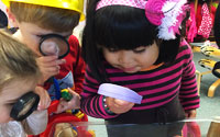 Explore | Children looking through magnifying glasses